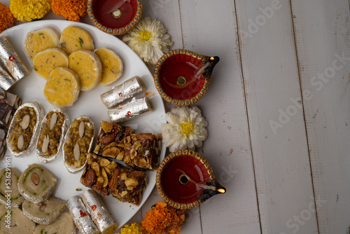 Mix indian sweets like kaju roll dryfruits barfi mango peda served in a plate photo