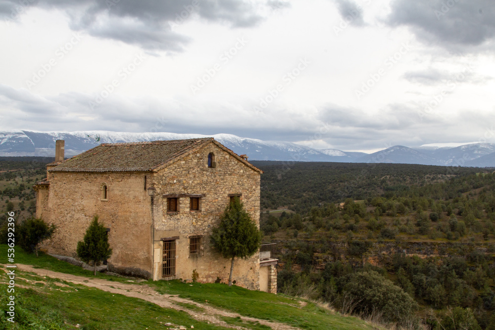 Casona en la villa de Pedraza. Al fondo se pueden ver las montañas nevadas de la sierra del Guadarrama. Segovia, Castilla y León, España.