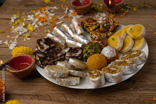 Mix indian sweets like kaju roll dryfruits barfi mango peda served in a plate photo