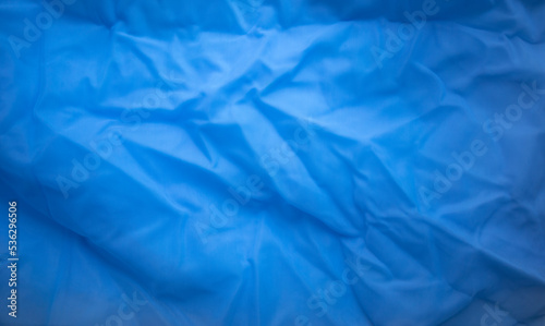 Photo of the texture of the blue fabric. The background is blue for the text. Sale of material for the manufacture of clothing.