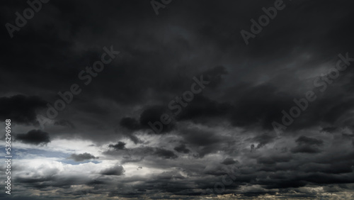 dark dramatic sky with black stormy clouds before rain or snow as abstract background, extreme weather, the sun shines through the clouds, high contrast photo © soleg
