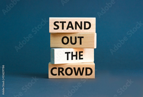 Stand out the crowd symbol. Concept words Stand out the crowd on wooden blocks on beautiful grey table grey background. Business  stand out the crowd concept