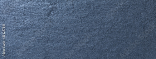 Navy blue background of natural slate. Texture of rough dark cool gray stone backdrop, closeup.