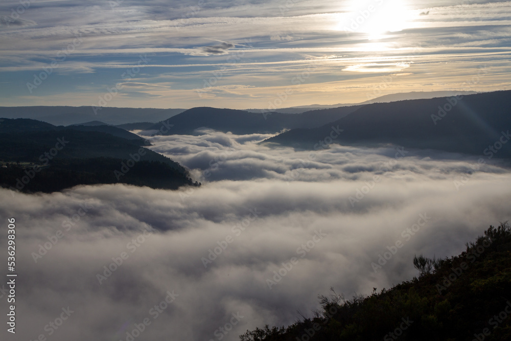 Amanece y el cauce del río Sil está lleno de niebla, por encima brilla el sol. Ribeira Sacra, Galicia, España.
