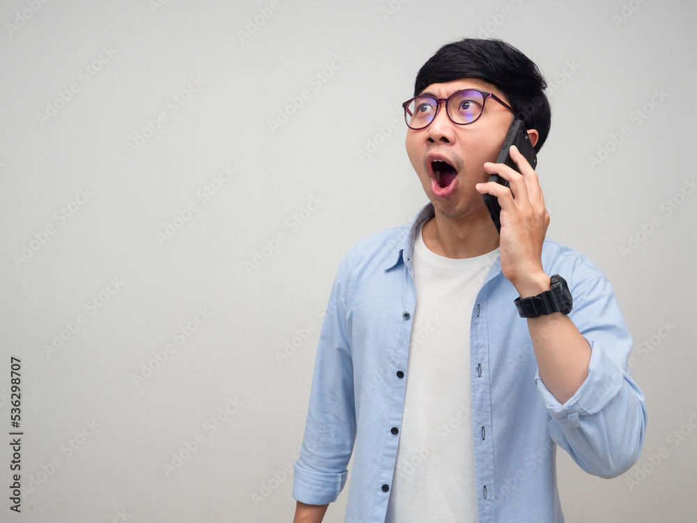 Young asian man glasses hold mobile phone feels amazed isolated Young asian man glasses hold mobile phone feels amazed isolated