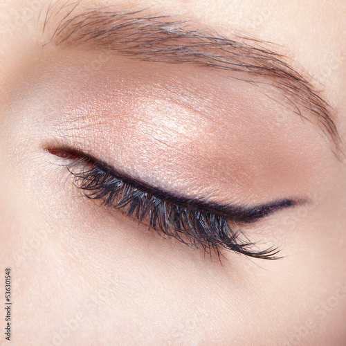 Closeup macro shot of closed human female eye with  light pink  eyes shadows