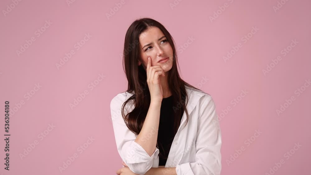 4k video of young woman planning something looking inspired over pink background. 4k video of young woman planning something looking inspired over pink background.