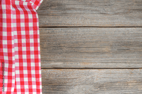 Checkered tablecloth on a wooden background. There is a place for your text.