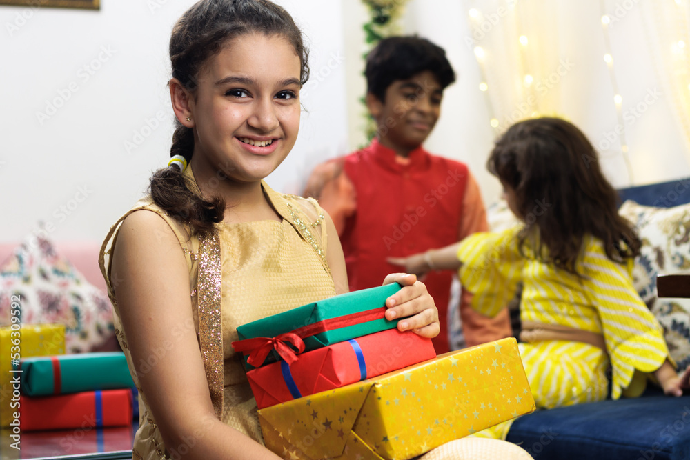 Young girl, kid, dressed up in ethnic wear excited with the gift and expression celebrating diwali Hindu festival Laxmi poojan Young girl, kid, dressed up in ethnic wear excited with the gift and expression celebrating diwali Hindu festival Laxmi poojan