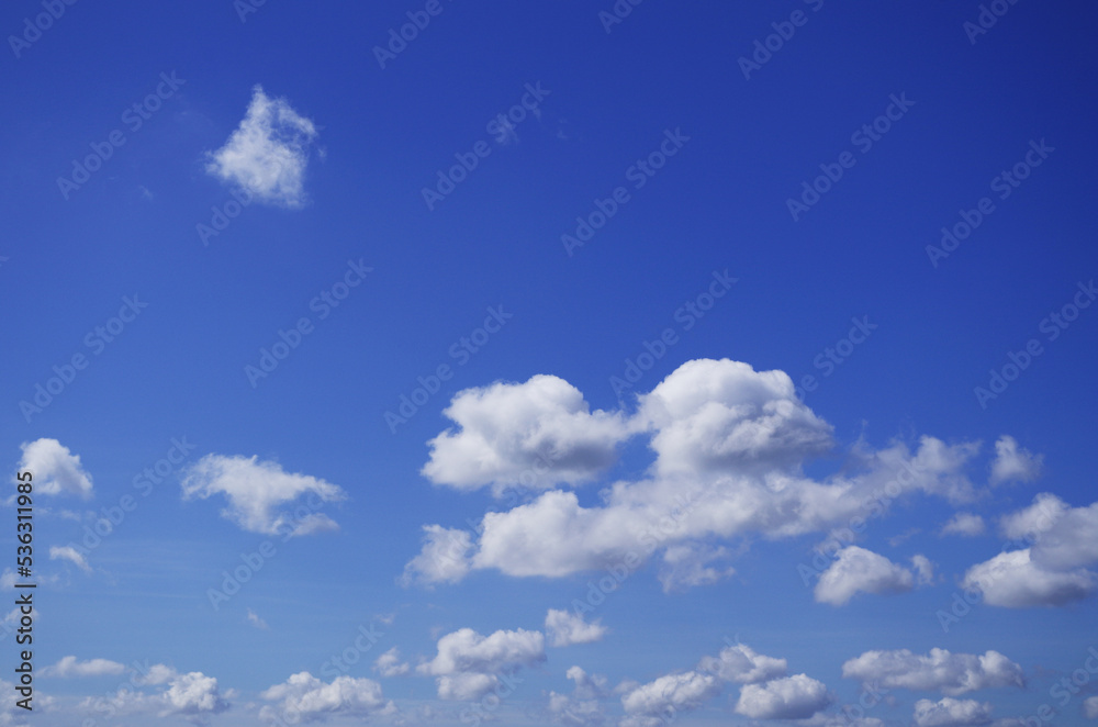 The blue sky with fluffy clouds in summertime