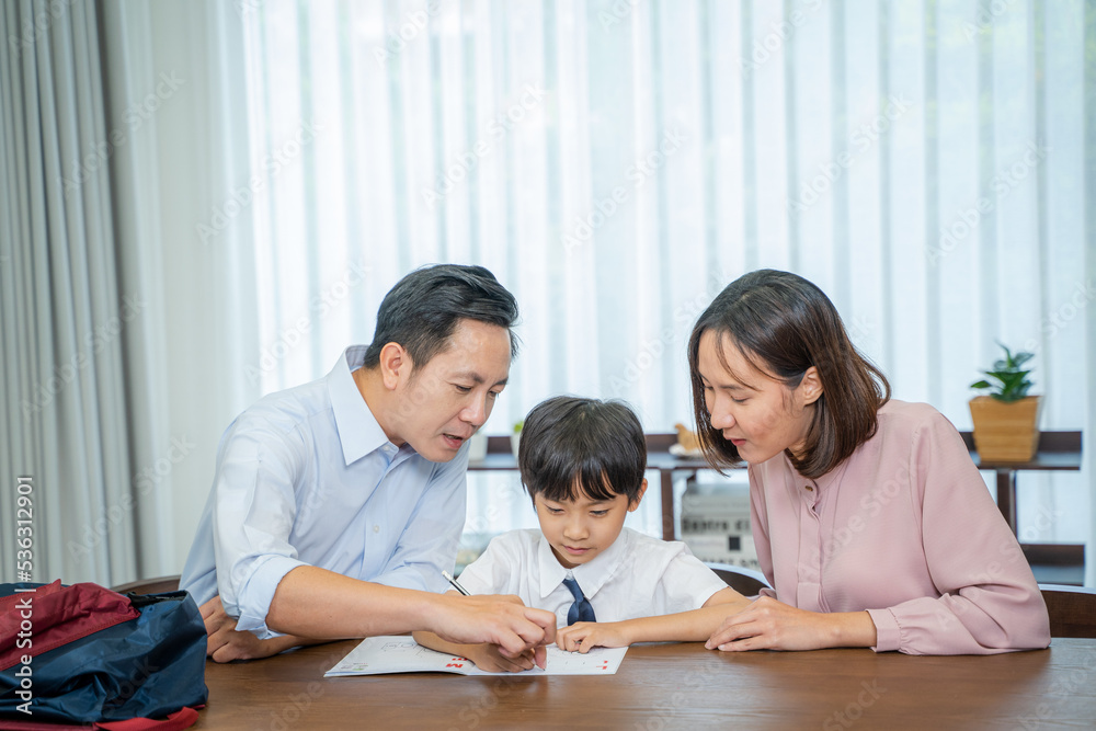 Parents helping little son with school homework,Homeschooling concept.