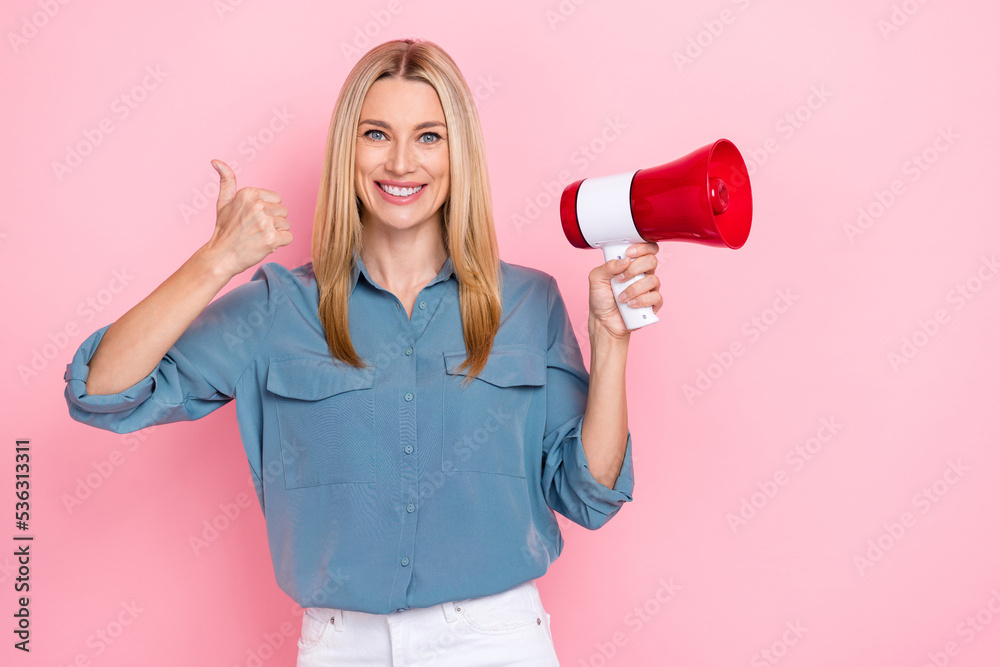 Photo of mature positive excited nice toothy smile lady wear office blue shirt showing thumb up like hold megaphone protest isolated on pink color background - obrazy, fototapety, plakaty 