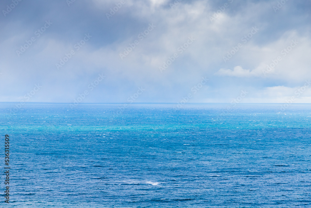 Blue sea is under cloudy sky on a c cloudy day Blue sea is under cloudy sky on a c cloudy day