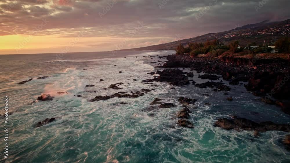 Beautiful aerial drone shot of deep blue sea and coastal area of reunion island with waves crashing at rocks while sunset Beautiful aerial drone shot of deep blue sea and coastal area of reunion island with waves crashing at rocks while sunset