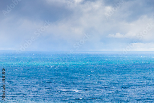 Blue sea is under cloudy sky on a c cloudy day