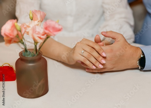 Close-up diamond ring proposal couple holding hands