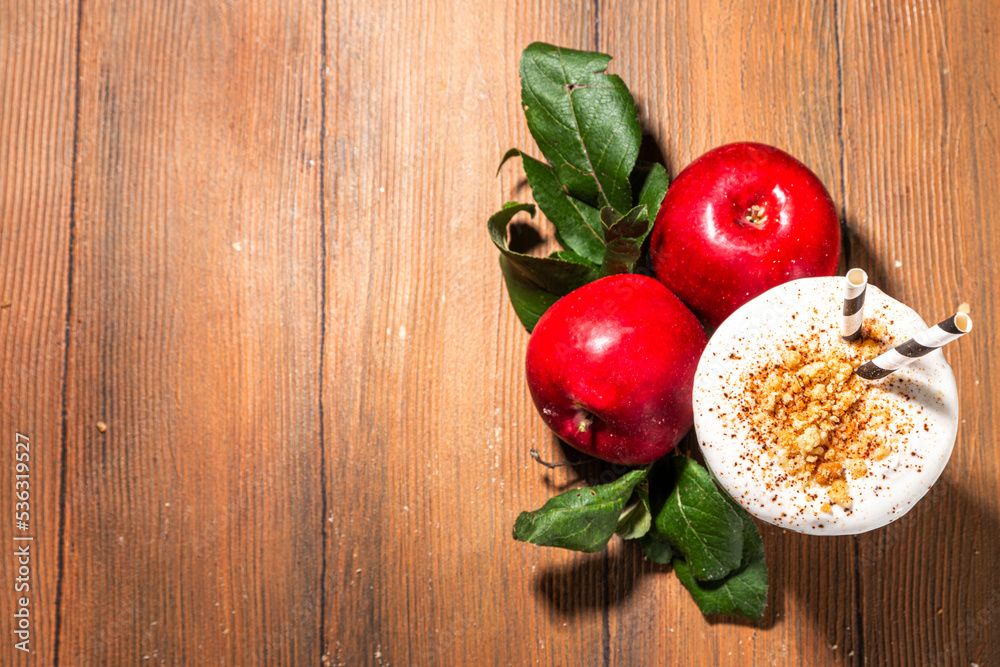 Homemade loaded apple pie milk shake, red autumn apple protein smoothie with tart crumble and spices, healthy fall seasonal breakfast drink, on cozy wooden background copy space Homemade loaded apple pie milk shake, red autumn apple protein smoothie with tart crumble and spices, healthy fall seasonal breakfast drink, on cozy wooden background copy space