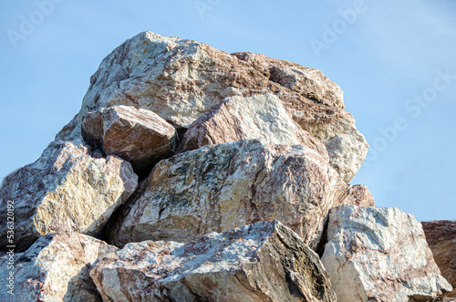 pile of stones. Rocks. Large decorative granite stones used in landscape design. stones against the blue sky. Mining industry, quarry