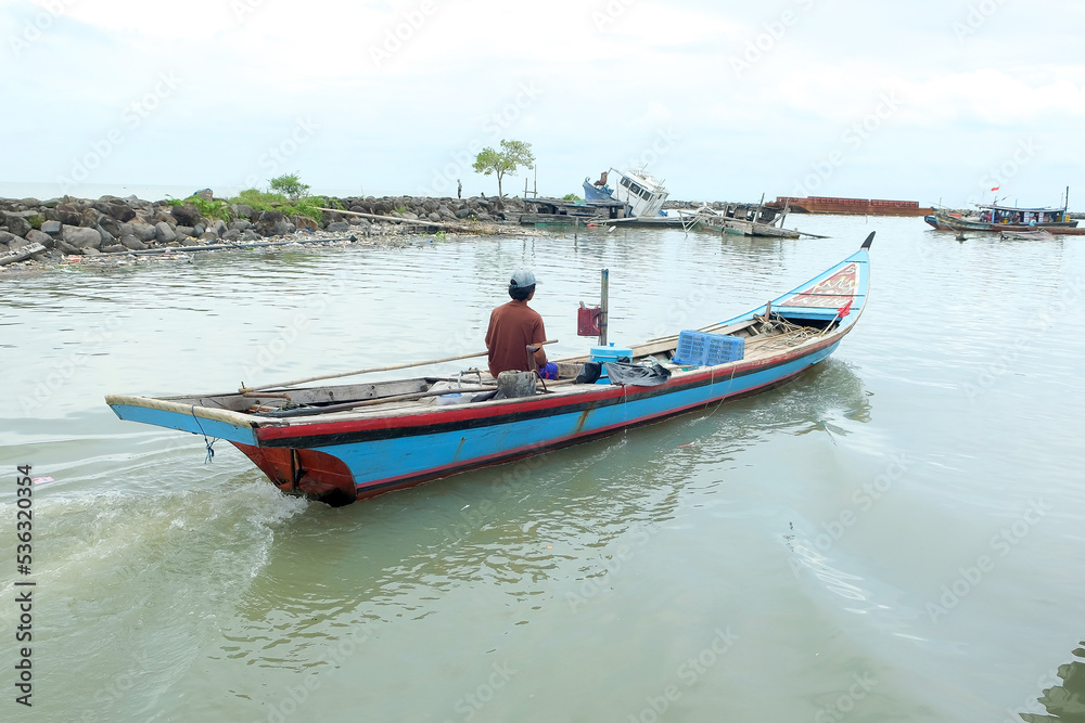 Fototapeta premium A fishing boat cruises in the water, this boat is used as a fishing boat by local Indonesian fishermen. The fishing boat goes to sea