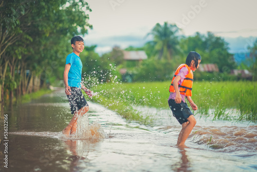 Children playing water of flooding in countryside