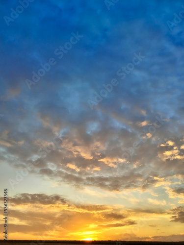 Abstraction of colorful orange and blue clouds in the sky during sunset.