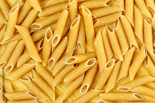 Whole grain penne pasta from durum wheat. Top view. Texture