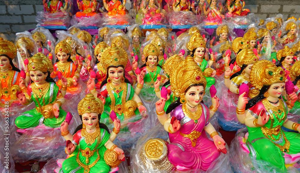 Beautiful statues of godess Lakshmi newly made in different style displayed for sale during festival of Diwali. Handcrafted Laxmi idols for Diwali celebration are ready to sell.