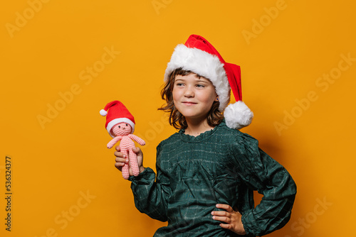 Girl standing with crochet toy on Christmas eve photo