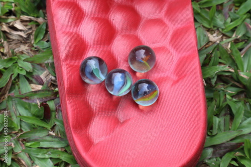 Colorful glass marbles on red background