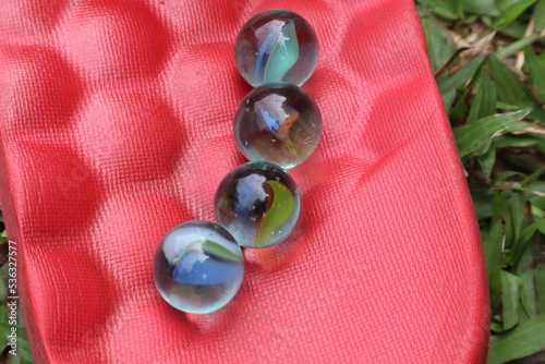 Colorful glass marbles on red background