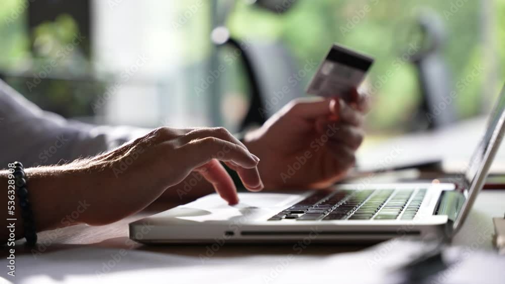 Close up hand man using laptop computer with credit card e-commerce shopping online and making internet banking Close up hand man using laptop computer with credit card e-commerce shopping online and making internet banking
