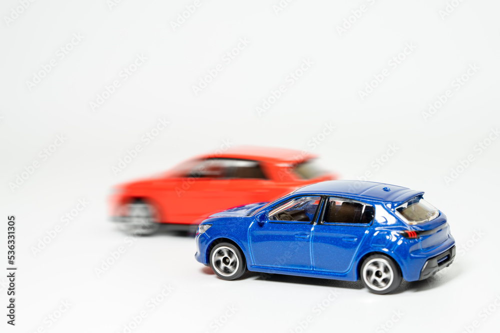 青い車を赤い車が追い抜くイメージ