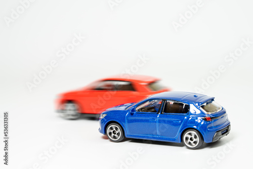 青い車を赤い車が追い抜くイメージ