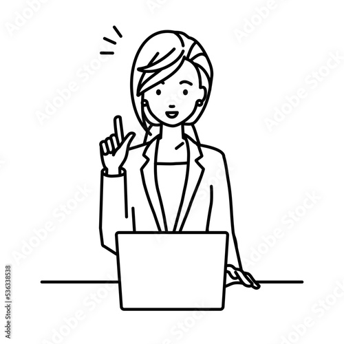 デスクで座ってPCを開いて何かひらめいたスーツの女性