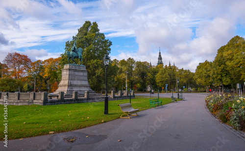 Panorama park view, king on horse cupper statue and museum gothic tower a colorful sunny autumn day in Stockholm
