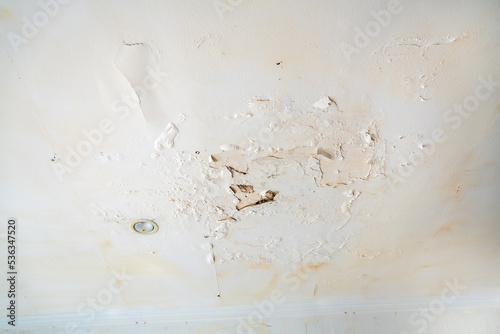 Valokuva Rain water leaks on the wall causing damage and peeling paint next to some light