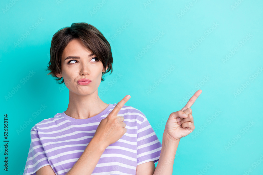 Portrait of minded pretty lady interested look empty space two arm direct index cool shop sale discount isolated on cyan color background Portrait of minded pretty lady interested look empty space two arm direct index cool shop sale discount isolated on cyan color background