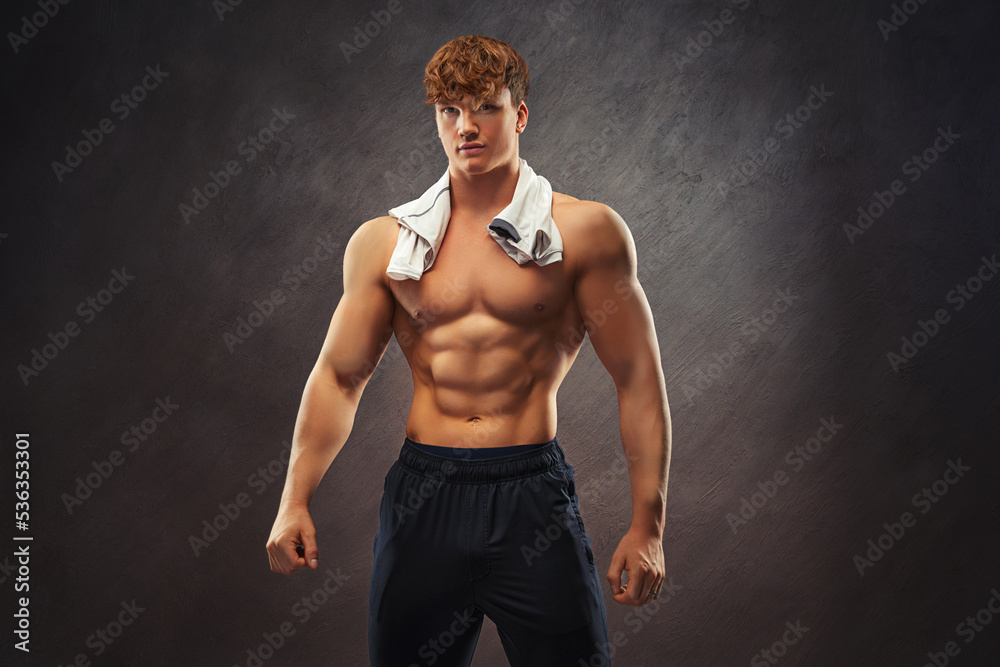 The torso of attractive muscular male body builder on black background