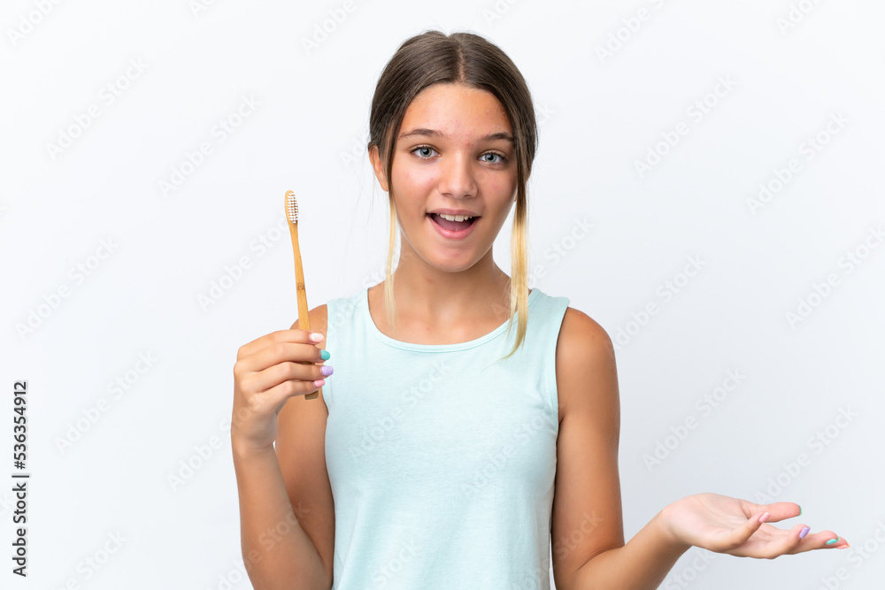 Little caucasian girl holding a toothbrush isolated on white background with shocked facial expression Little caucasian girl holding a toothbrush isolated on white background with shocked facial expression