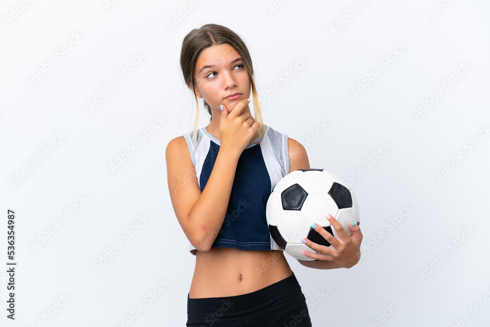 Little caucasian girl playing football isolated on white background having doubts Little caucasian girl playing football isolated on white background having doubts