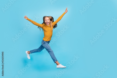 Full length photo of overjoyed excited person jumping rejoice empty space isolated on blue color background