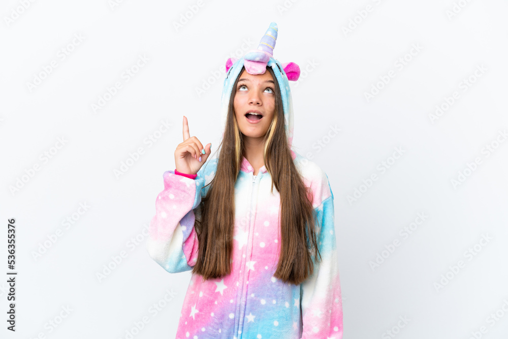 Little caucasian girl wearing unicorn pajama isolated on white background pointing up and surprised
