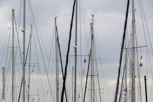 ship masts in a port with clouds