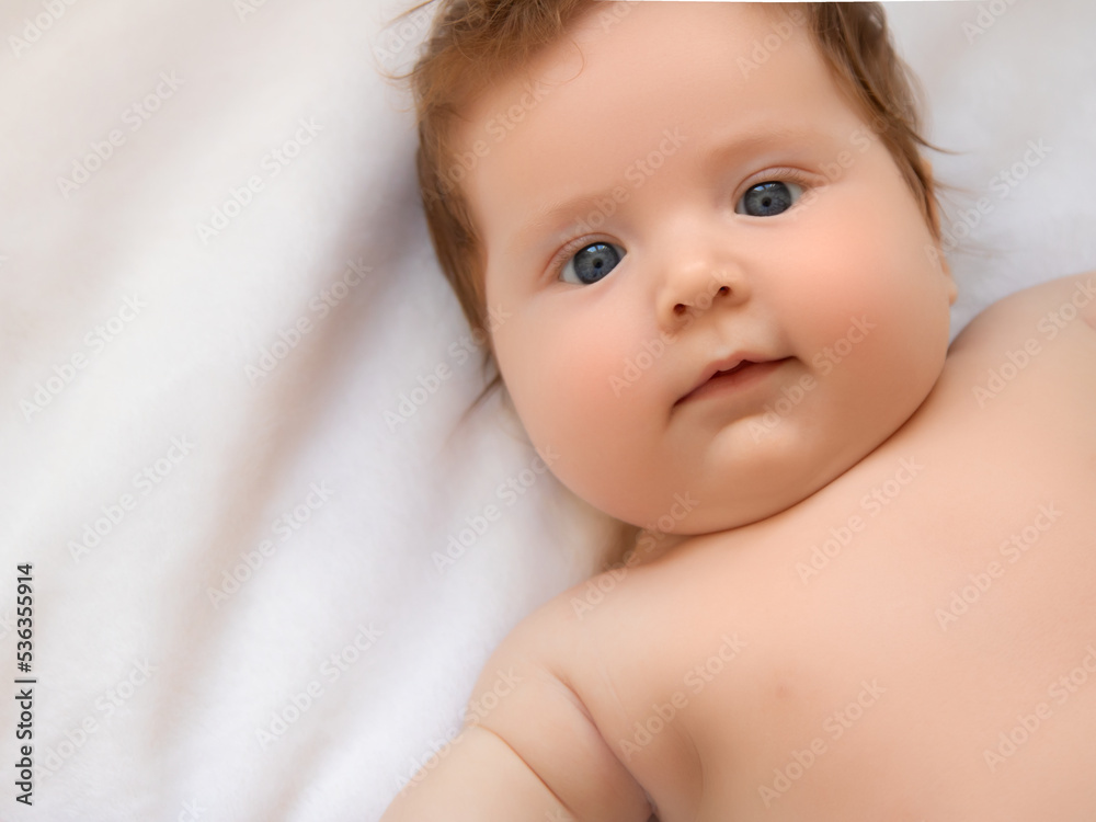 Baby girl in white sunny bedroom. Newborn child relaxing in bed. Nursery for children. Textile and bedding for kids. Family morning at home. New born kid during tummy time Baby girl in white sunny bedroom. Newborn child relaxing in bed. Nursery for children. Textile and bedding for kids. Family morning at home. New born kid during tummy time