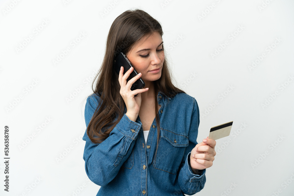 Young caucasian woman isolated on white background buying with the mobile with a credit card Young caucasian woman isolated on white background buying with the mobile with a credit card