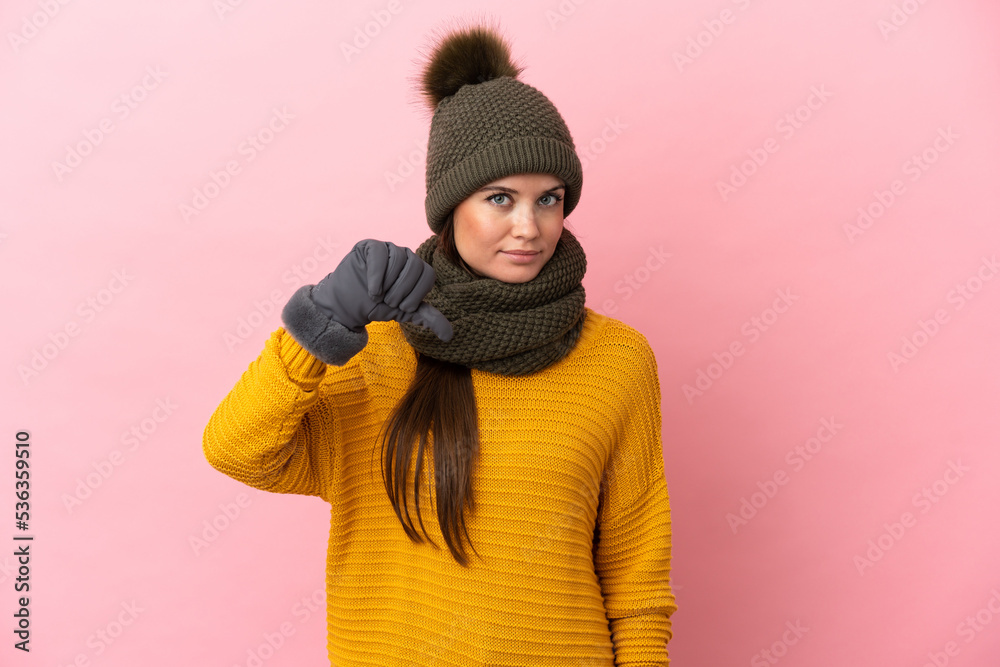 Young caucasian girl with winter hat isolated on pink background showing thumb down with negative expression Young caucasian girl with winter hat isolated on pink background showing thumb down with negative expression
