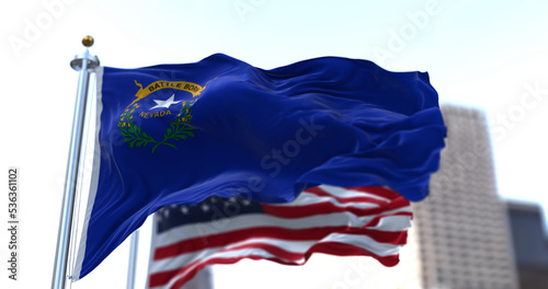 The flags of the Nevada state and United States of America waving in the wind. Democracy and independence