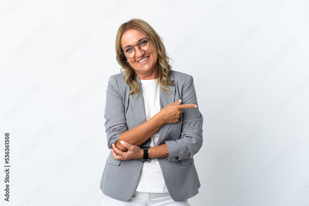 Middle aged business woman over isolated white background pointing to the side to present a product Middle aged business woman over isolated white background pointing to the side to present a product