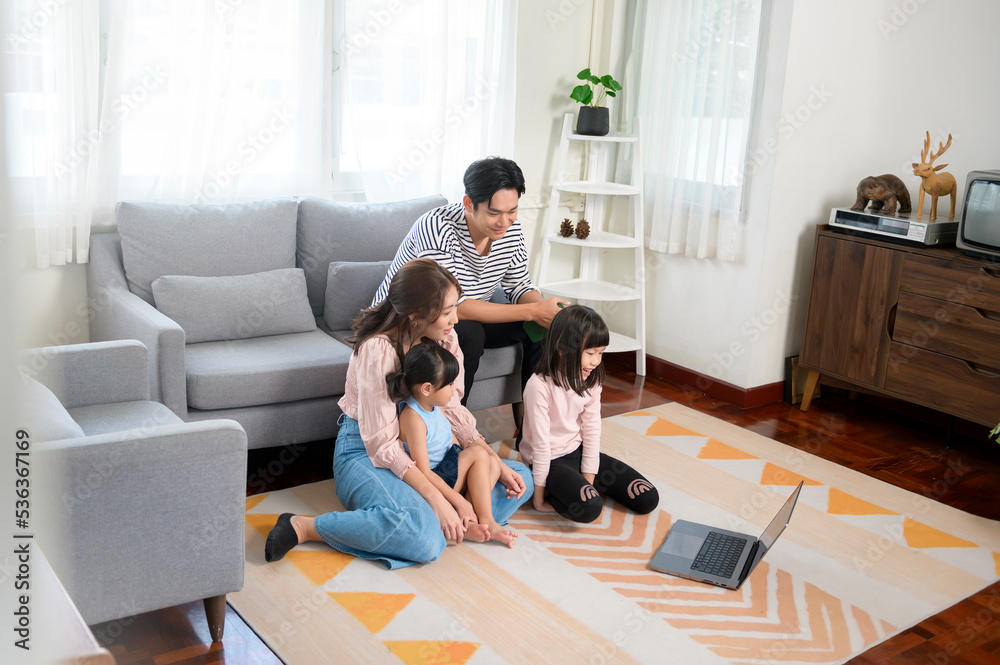Asian family with children using laptop computer at home