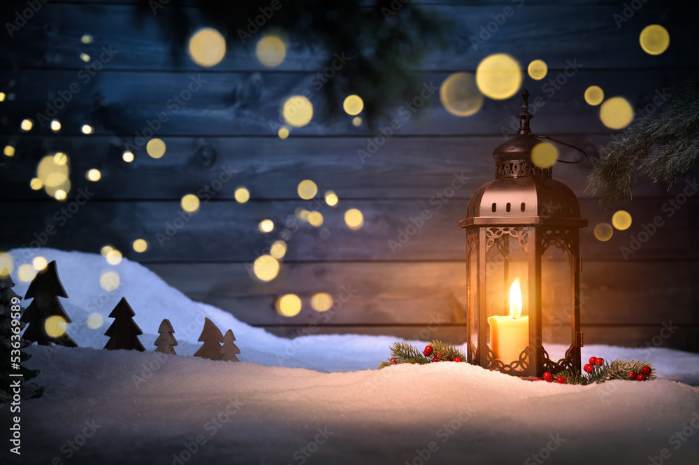 Φωτογραφία Christmas scene with a lantern, ornaments and blurred lights hanging in front of a dark wooden wall